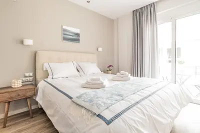 a white bedroom with a large bed with towels on it at A14 Sunny & chic 2Room apartment near Plaka & Parthenon in Athens