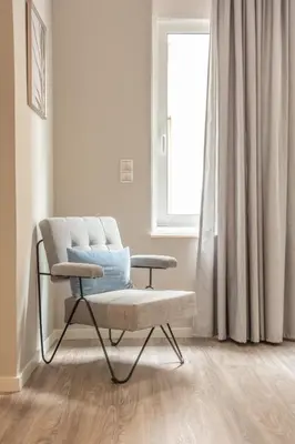 a chair in a living room with a window at A14 Sunny & chic 2Room apartment near Plaka & Parthenon in Athens