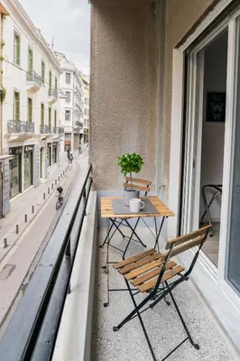 a table and chairs on the balcony of a building at A14 Sunny & chic 2Room apartment near Plaka & Parthenon in Athens