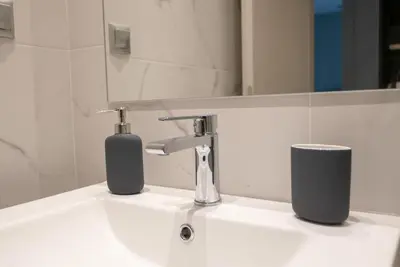 a bathroom sink with a faucet and a mirror at A14 Sunny & chic 2Room apartment near Plaka & Parthenon in Athens