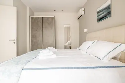 a bedroom with a white bed with towels on it at A14 Sunny & chic 2Room apartment near Plaka & Parthenon in Athens