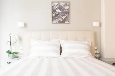 a bedroom with a white bed with white pillows at A17 Modern & Cosy 2Room flat up to 4ppl near Parthenon, 1Bedroom 1livingroom in Athens