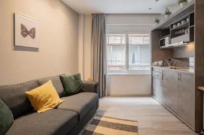 a living room with a couch and a kitchen at A17 Modern & Cosy 2Room flat up to 4ppl near Parthenon, 1Bedroom 1livingroom in Athens