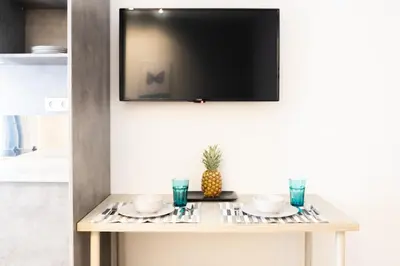 a table with two plates and a television on a wall at A17 Modern & Cosy 2Room flat up to 4ppl near Parthenon, 1Bedroom 1livingroom in Athens