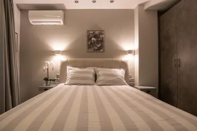 a bedroom with a large bed with two pillows at A17 Modern & Cosy 2Room flat up to 4ppl near Parthenon, 1Bedroom 1livingroom in Athens