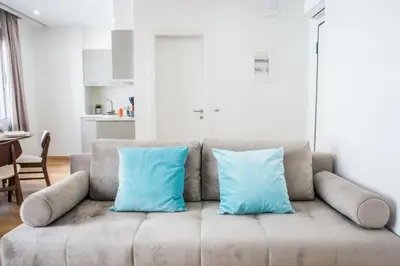 a couch with two blue pillows sitting in a living room at A23 Premium suite with balcony near Parthenon in Athens