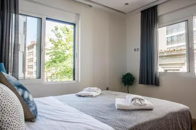 a bedroom with two towels on a bed with windows at A23 Premium suite with balcony near Parthenon in Athens