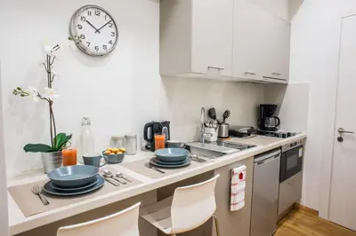 a kitchen with a counter with a clock on the wall at A21 Premium Suite a breath away from Parthenon! in Athens
