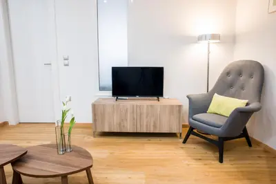 a living room with a tv and a chair and a table at A21 Premium Suite a breath away from Parthenon! in Athens
