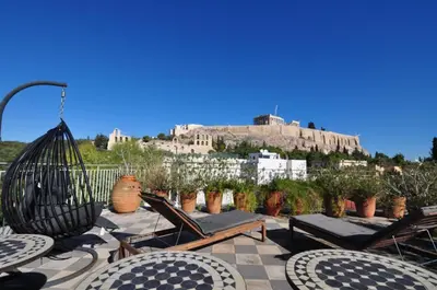 a patio with chairs and tables and a castle at Stunning Acropolis view apartment in Athens