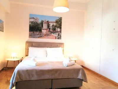 a bedroom with a bed with a painting on the wall at Stunning Acropolis view apartment in Athens