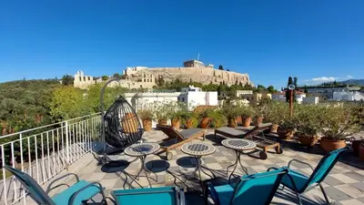 a patio with tables and chairs and a castle at Stunning Acropolis view apartment in Athens