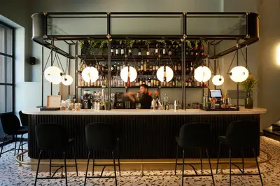a bar with a man sitting at a counter at The Port Square Hotel in Piraeus
