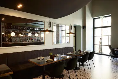 a restaurant with tables and chairs and a bar at The Port Square Hotel in Piraeus