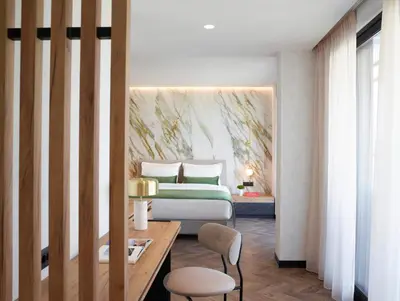 a bedroom with a bed and a table and chairs at The Port Square Hotel in Piraeus