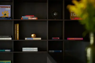 a book shelf filled with lots of books at The Port Square Hotel in Piraeus
