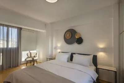 a bedroom with a bed with a clock on the wall at NEW STUNNING PENTHOUSE W/SPECTACULAR VISTAS! in Athens