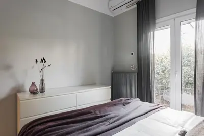 a white bedroom with a bed and a window at Unique 2BR Apartment in Filothei by UPSTREET in Athens