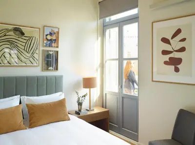 a bedroom with a bed and a window and a chair at Del Taso 1850 in Athens
