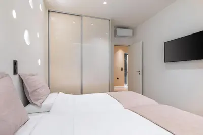 a bedroom with a white bed and a flat screen tv at J&A Luxury Residence in Athens