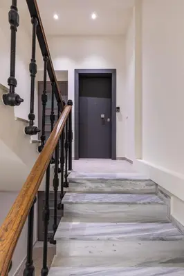 a hallway with stairs leading to a black door at J&A Luxury Residence in Athens