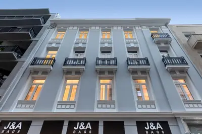 a tall white building with windows and balconies at J&A Luxury Residence in Athens