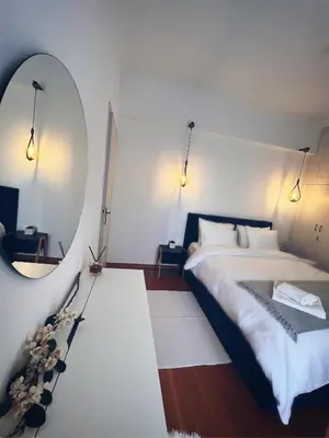 a bedroom with a large bed and a mirror at Seaside apartment in Flisvos marina in Athens