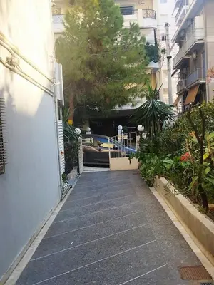 a walkway between two buildings with a boat in a canal at Seaside apartment in Flisvos marina in Athens