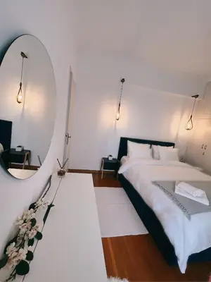 a bedroom with a large bed and a mirror at Seaside apartment in Flisvos marina in Athens