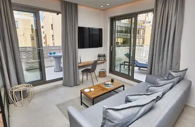 a living room with a couch and a tv at THE VAULT Brand New Loft in Athens Historic Center in Athens