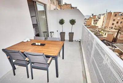 a wooden table and chairs on a balcony at THE VAULT Brand New Loft in Athens Historic Center in Athens