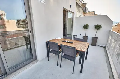 a balcony with a wooden table and chairs on it at THE VAULT Brand New Loft in Athens Historic Center in Athens