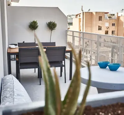 a patio with a table and chairs on a balcony at THE VAULT Brand New Loft in Athens Historic Center in Athens