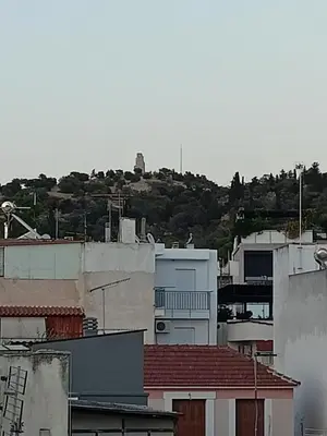 a group of buildings with a hill in the background at Modern-Lux Central 1 Bedroom Condo in Athens