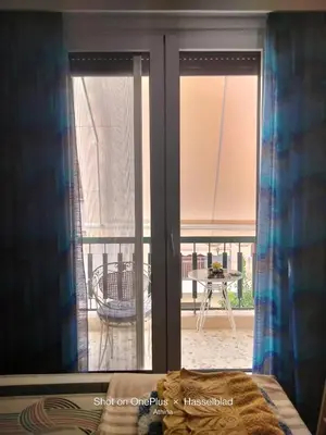 a bedroom with a window with a view of a balcony at Modern-Lux Central 1 Bedroom Condo in Athens