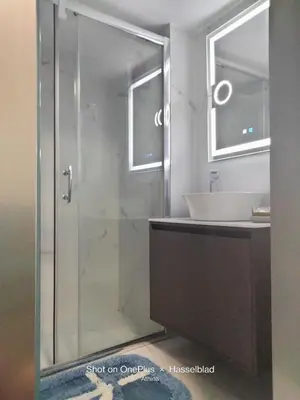 a bathroom with a glass shower and a sink at Modern-Lux Central 1 Bedroom Condo in Athens
