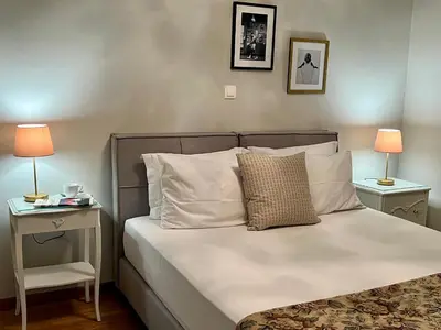 a bedroom with a bed with two tables and two lamps at Mrs Holiday Apartment in Athens