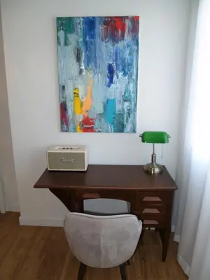 a desk with a chair and a painting on the wall at Mrs Holiday Apartment in Athens