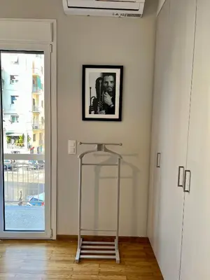 a glass stand in a room with a window at Mrs Holiday Apartment in Athens