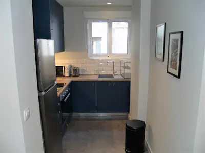 a kitchen with blue cabinets and a sink at Mrs Holiday Apartment in Athens