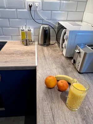 a kitchen counter with oranges and a glass of orange juice at Mrs Holiday Apartment in Athens