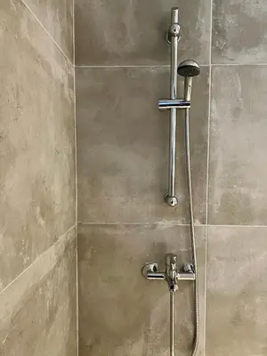 a shower with a shower head in a bathroom at Mrs Holiday Apartment in Athens