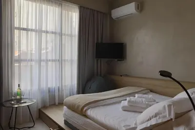 a hotel room with a bed with towels on it at ATHENS LUX CASA, Urban Eco Suites in Athens