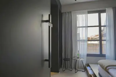 a bedroom with a bed and a window and a table at ATHENS LUX CASA, Urban Eco Suites in Athens