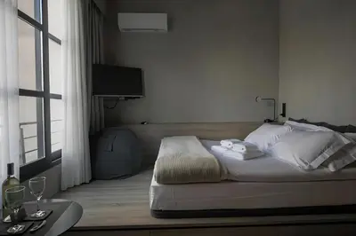 a bedroom with a bed with white pillows and a window at ATHENS LUX CASA, Urban Eco Suites in Athens