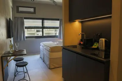 a hotel room with a bed and a kitchen with a sink at ATHENS LUX CASA, Urban Eco Suites in Athens