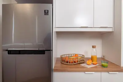 a kitchen with a refrigerator and a basket of oranges at Athens Loft by Phoenix Apartments in Athens