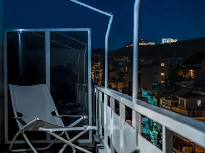a chair sitting on a balcony at night at Athens Loft by Phoenix Apartments in Athens