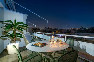 a table on a balcony with glasses of wine at Athens Loft by Phoenix Apartments in Athens