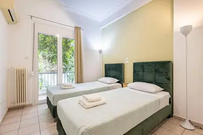 two beds in a room with a window at Acropolis Stylish 2BR Apartment - Center of Athens in Athens